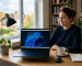 Laptop displaying a Windows 11 installation stuck during setup in a modern home office